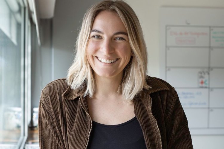 Valerie Hentschel im Office - hinter ihr unscharf Glas und Charts